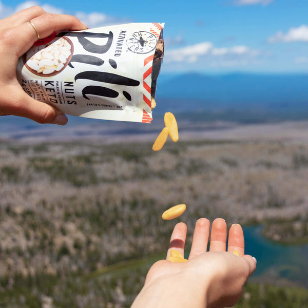 pili hunters spicy chili nuts nuts pouring into a snacker's hand