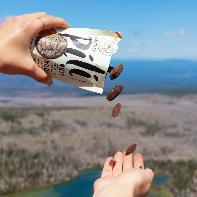 pili hunters nuts with raw cacao pouring into snacker's hand