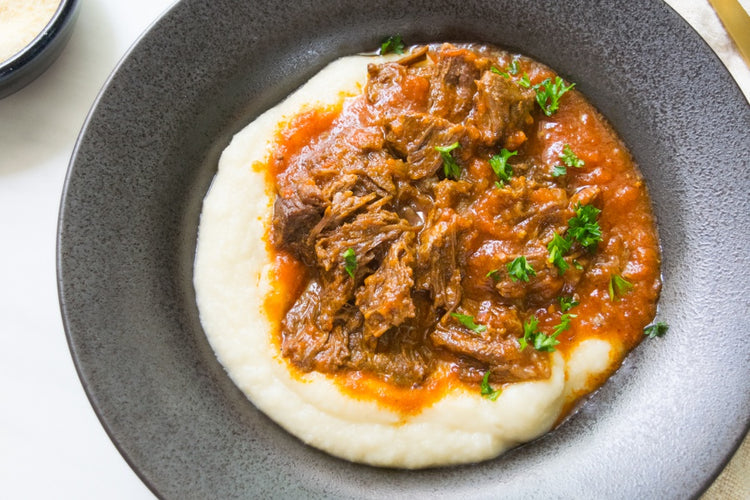 slow cooked beef cheeks in dish with potatoes
