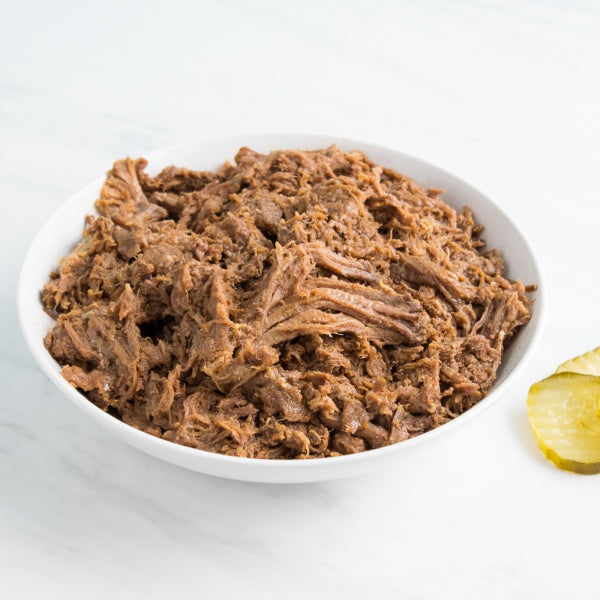 shredded BBQ Beef in a bowl with pickles