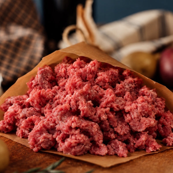 raw grassfed 90% lean ground beef in butcher paper on a counter with potatoes