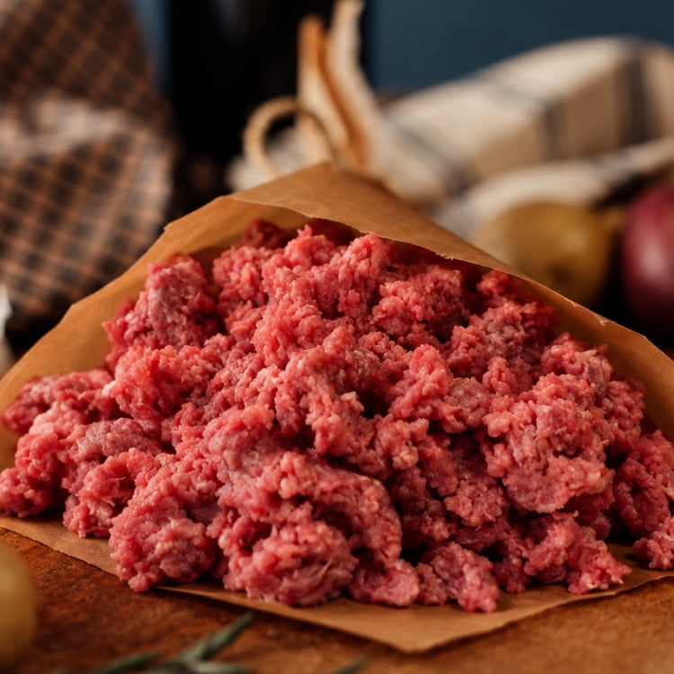 raw grassfed 90% lean ground beef in butcher paper on a counter with potatoes