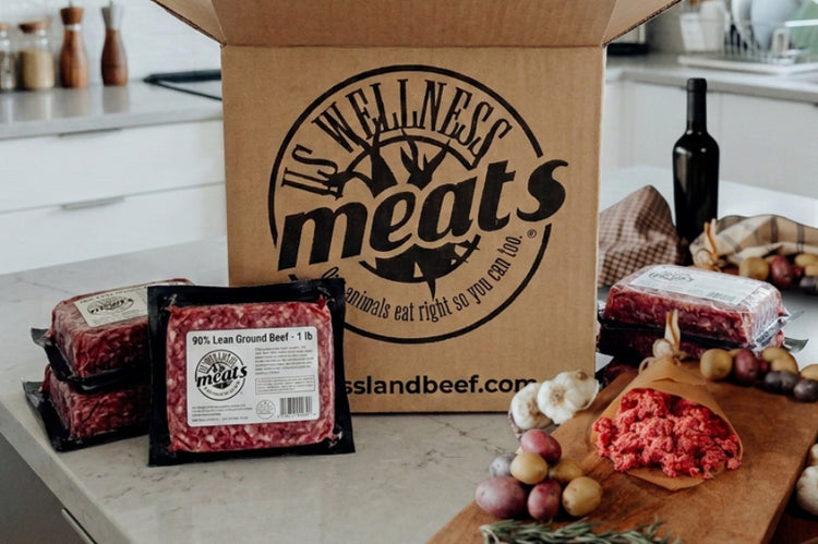 90% Lean Ground Beef individual packages on a kitchen counter with US Wellness Meats box