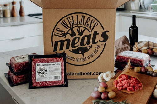 90% Lean Ground Beef individual packages on a kitchen counter with US Wellness Meats box