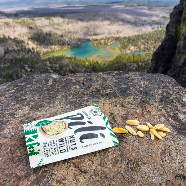 pili hunters rosemary and olive nuts package on a rock overlooking lake