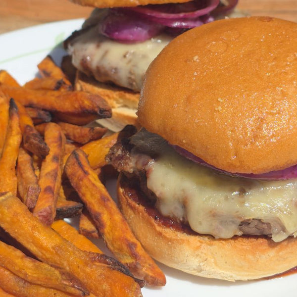 ground beef burger with melted cheese paired with sweet potato fries