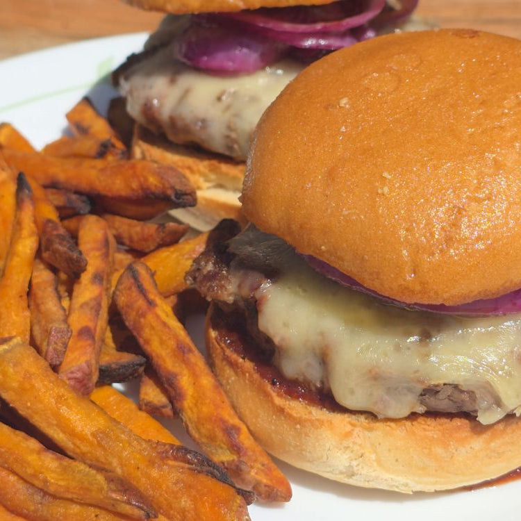 ground beef burger with melted cheese paired with sweet potato fries