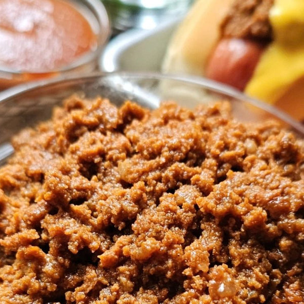 Chili ground beef in a bowl, hot dogs topped with chili ground beef