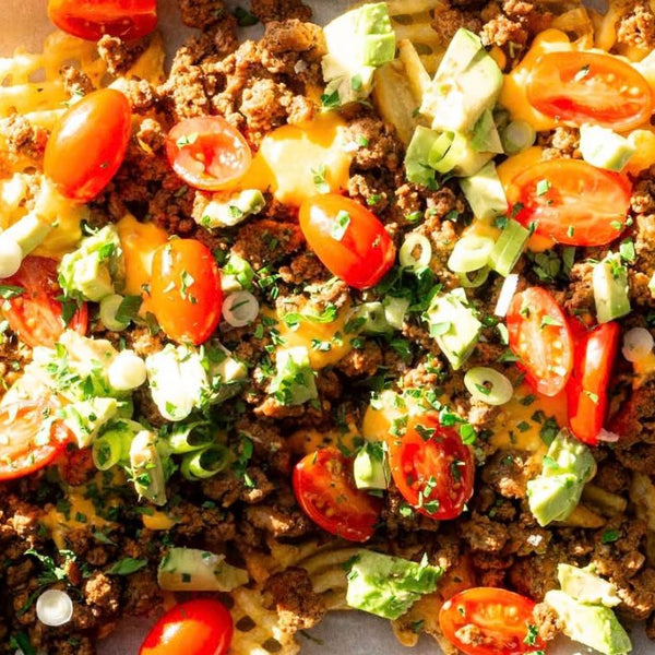 Waffle fries topped with ground beef, tomatoes, cheese, avocado and sauce