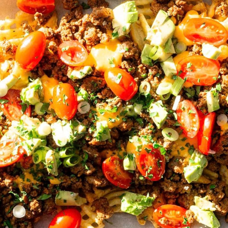 Waffle fries topped with ground beef, tomatoes, cheese, avocado and sauce