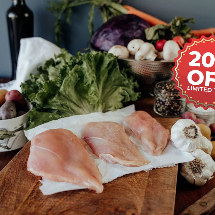 Raw chicken breasts on a wooden cutting board with vegetables and a '20% off' promotion sign.
