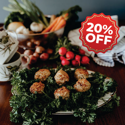 Plated dish of chicken sausage meatballs with vegetables on a table, featuring a 20% off discount sign.