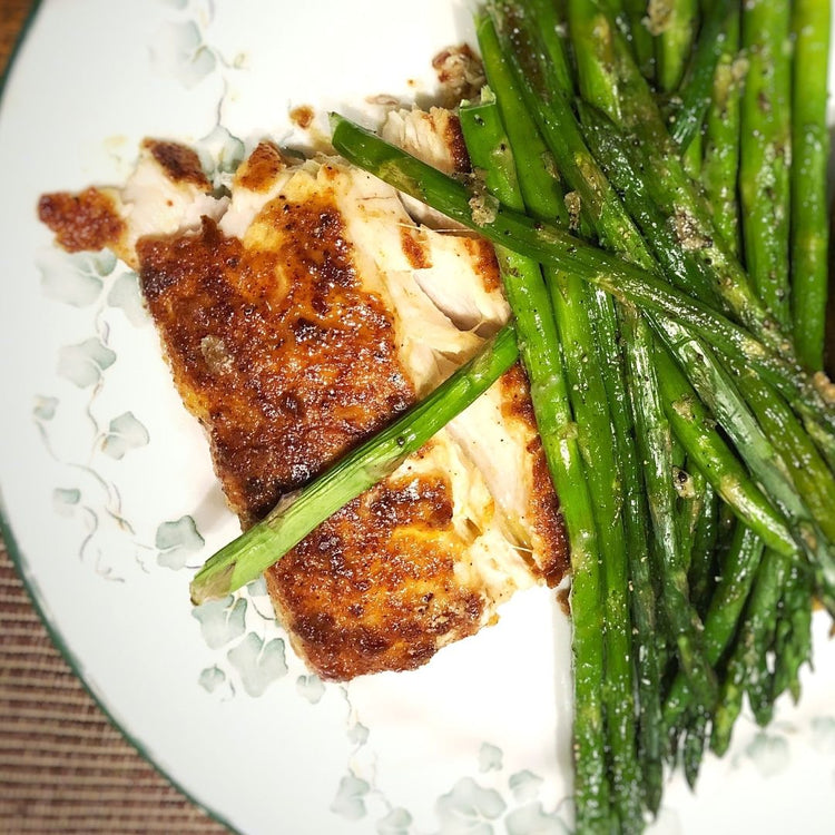 Grilled chicken with asparagus on a white plate