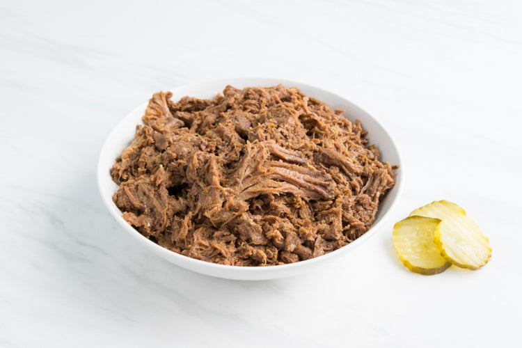 shredded BBQ Beef in a bowl with pickles
